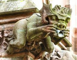 Freiburský chrlič působí současně strašidelně i komicky. Prsty roztahuje do široka svou tlamu, což je jasné gesto svědčící o jeho funkci odpuzovače démonů. http://www.stavitele-katedral.cz/komika-ve-stredovekem-vytvarnem-umeni-prisera-s-vejirovityma-usima/&thinsp;external link 